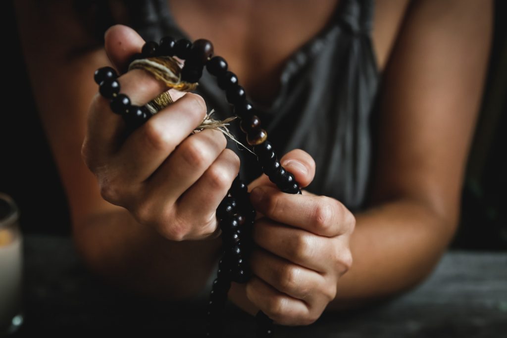 hands holding a black rosary